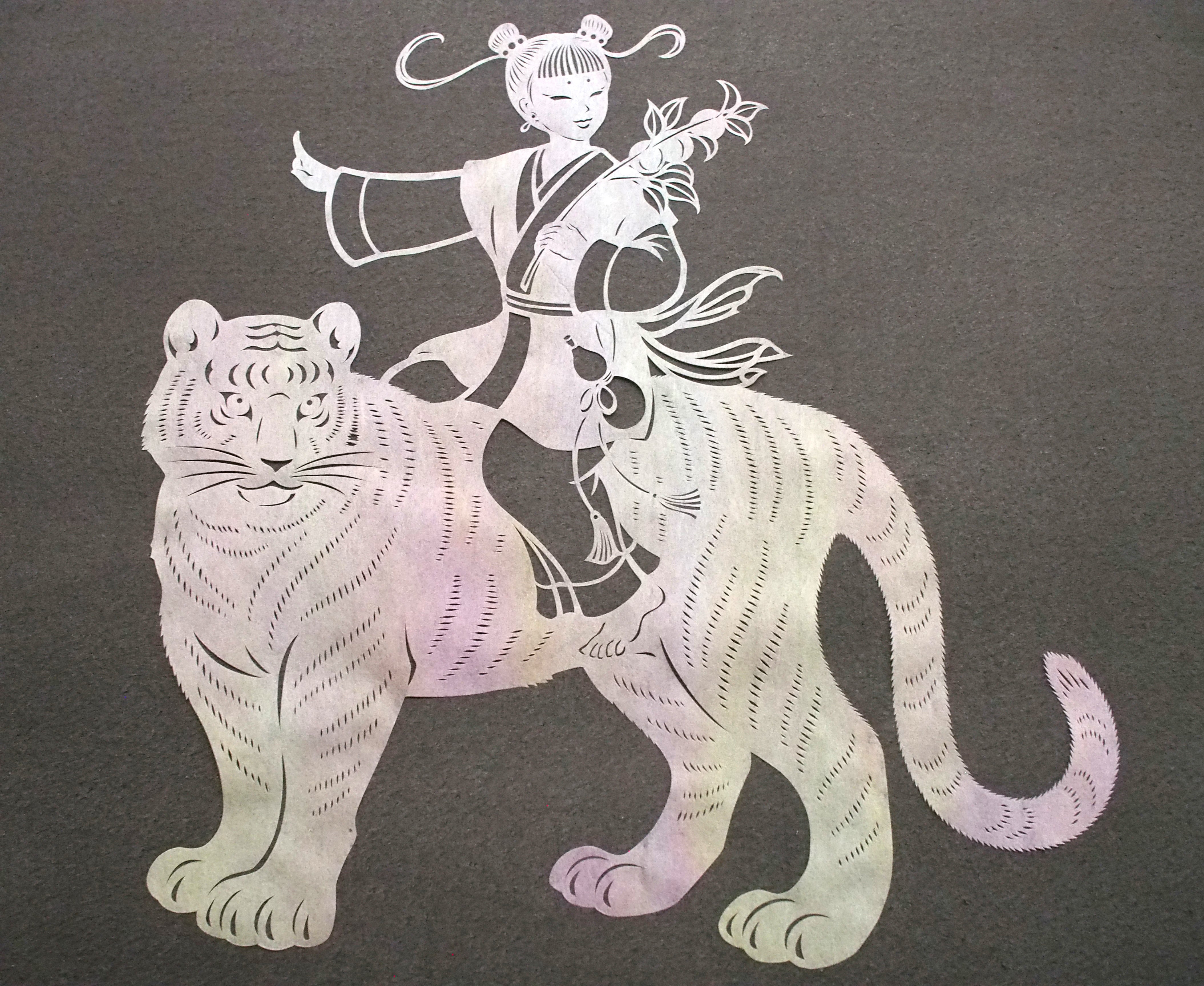 Art de coupe en papier / un enfant chevauchant un tigre