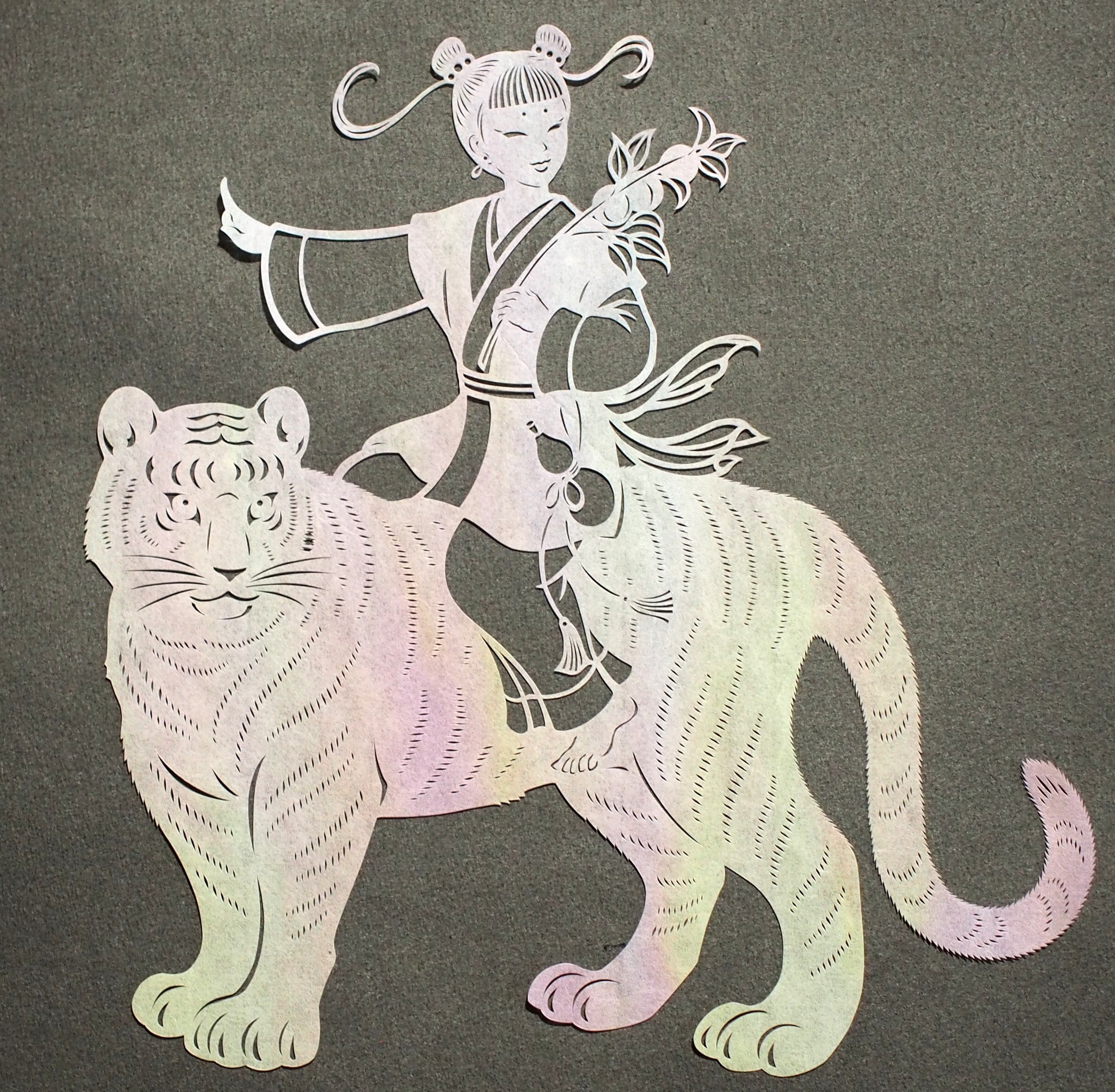 Art de coupe en papier / un enfant chevauchant un tigre
