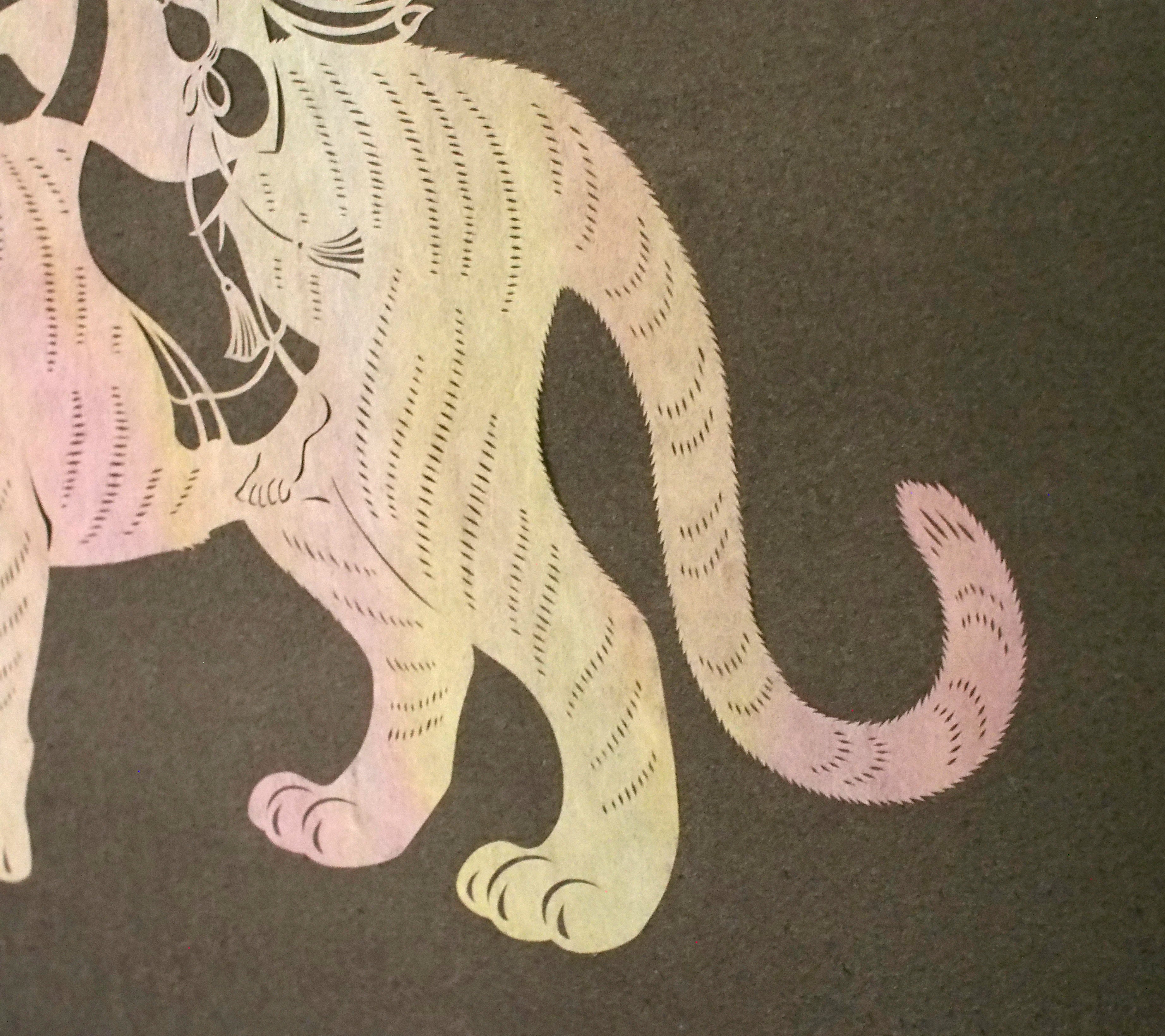 Art de coupe en papier / un enfant chevauchant un tigre