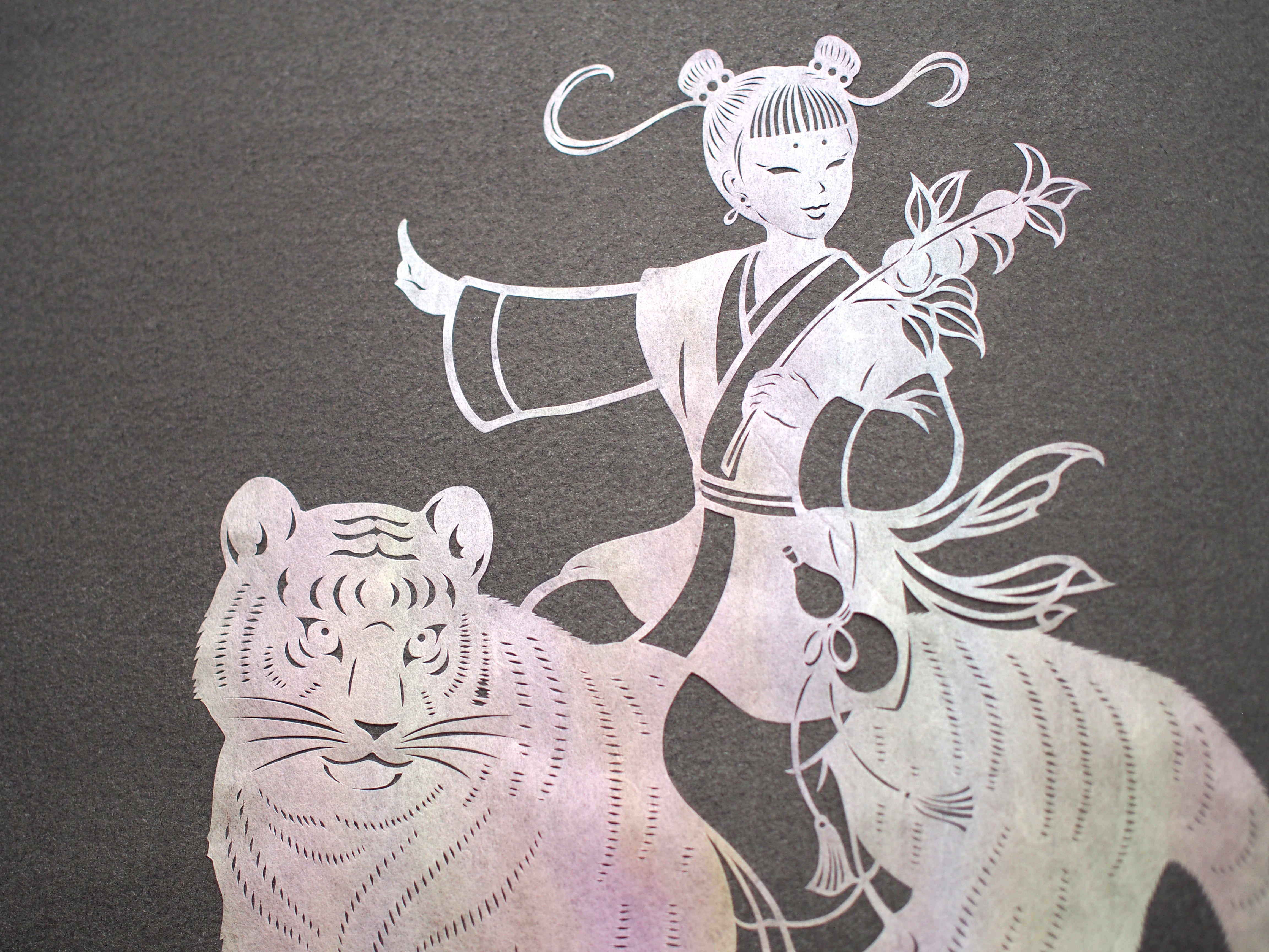 Art de coupe en papier / un enfant chevauchant un tigre