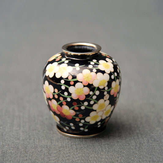 Vase rond / noir transparent rempli de fleurs de prune