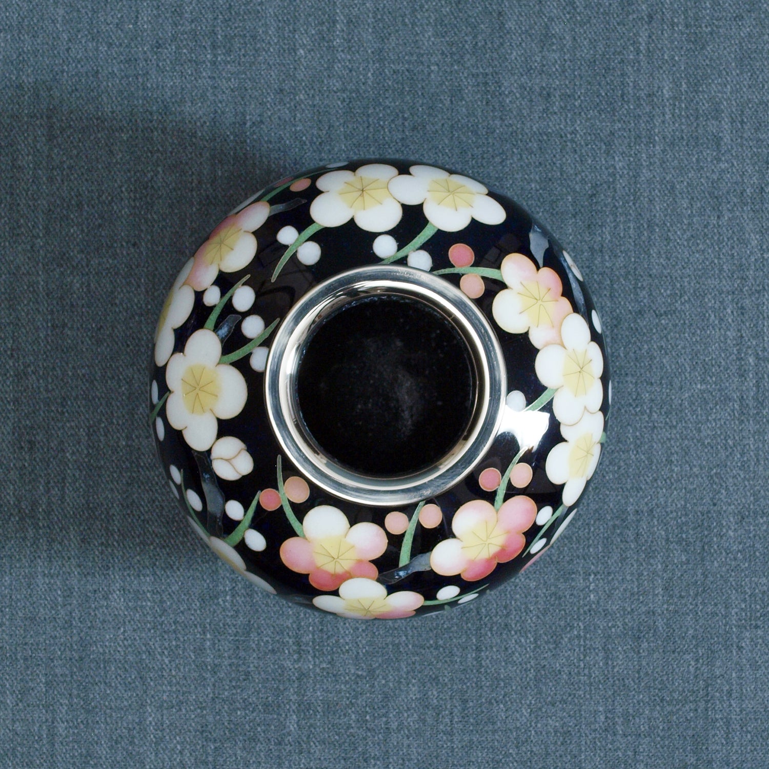 Vase rond / noir transparent rempli de fleurs de prune